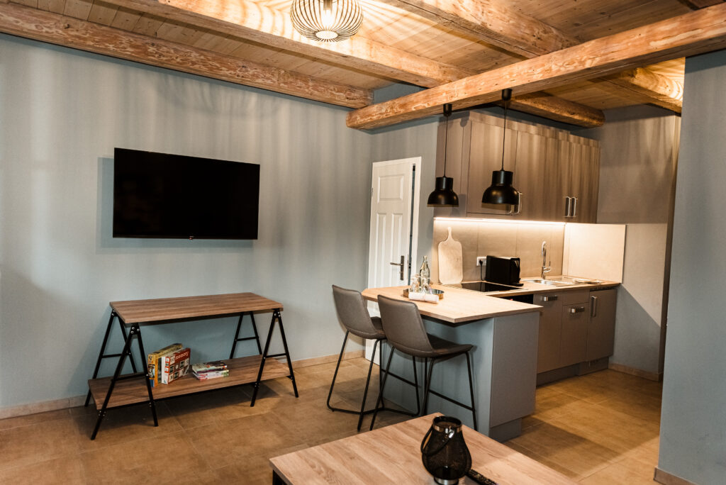 Moderne Küchenzeile mit gemütlichen Essplatz und Holzbalkendecke in der Ferienwohnung auf Bussjans Hof.