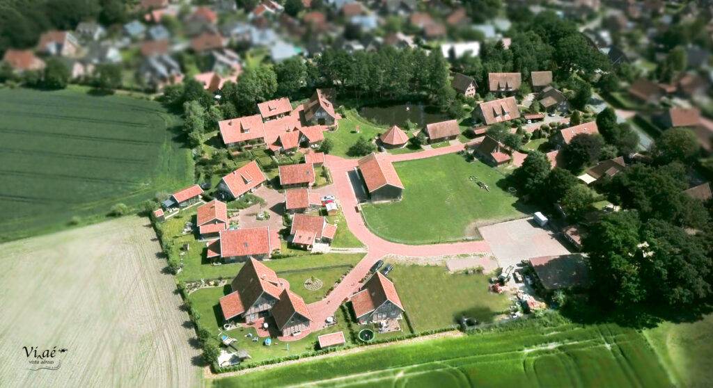 Aktuelle Luftaufnahme der Hofanlage mit grüner Wiese, roten Ziegeldächern und Fachwerkhäusern.