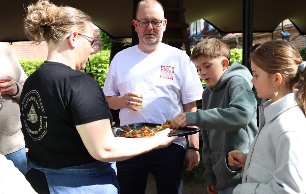 Gemeinsam Essen im Freien - Gäste genießen frisch zubereitete Speisen auf Bussjans Hof