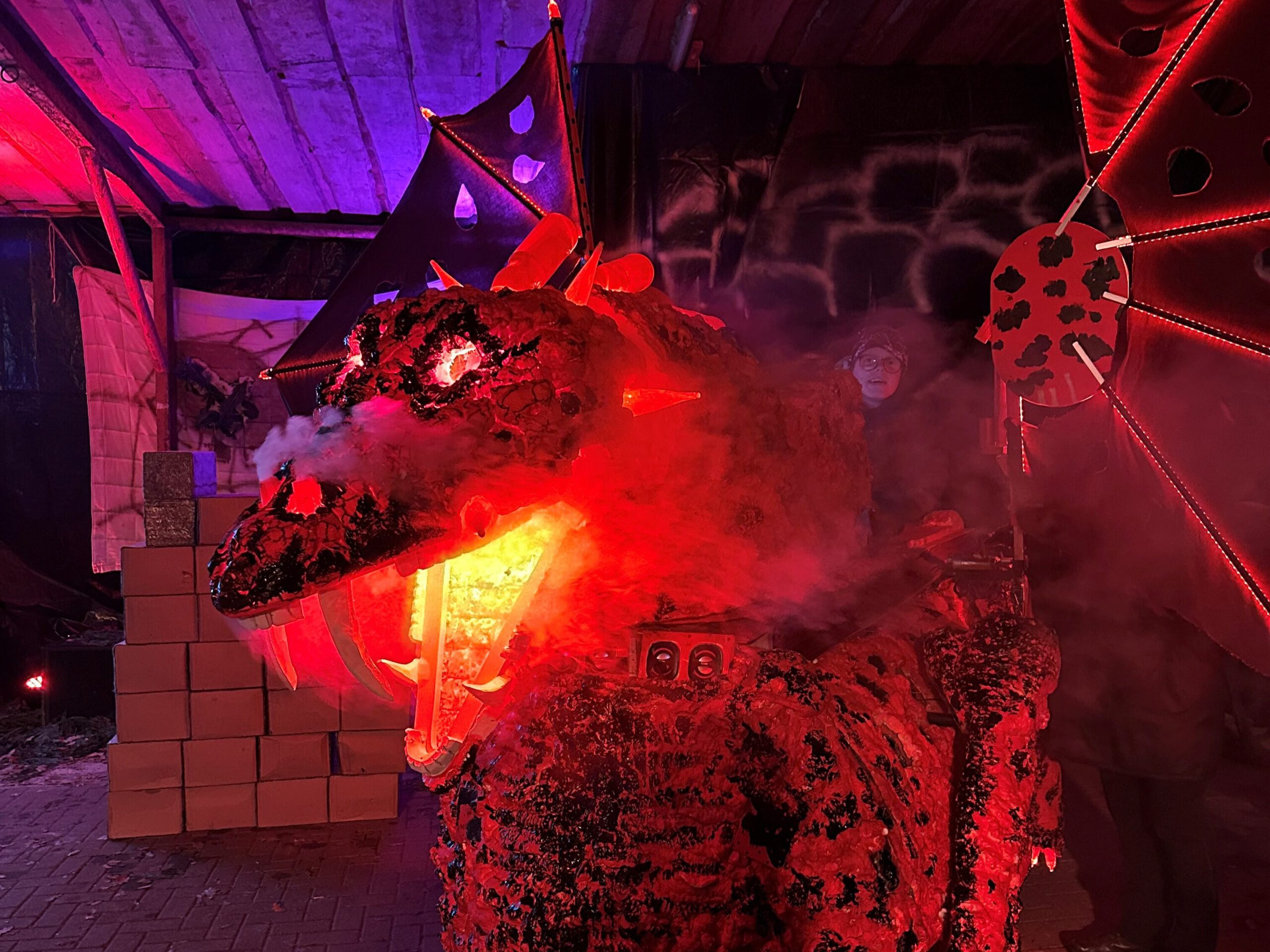 Leuchtende Drachenfigur mit Feuereffekt und Halloween-Kulisse beim Event auf Bussjans Hof.